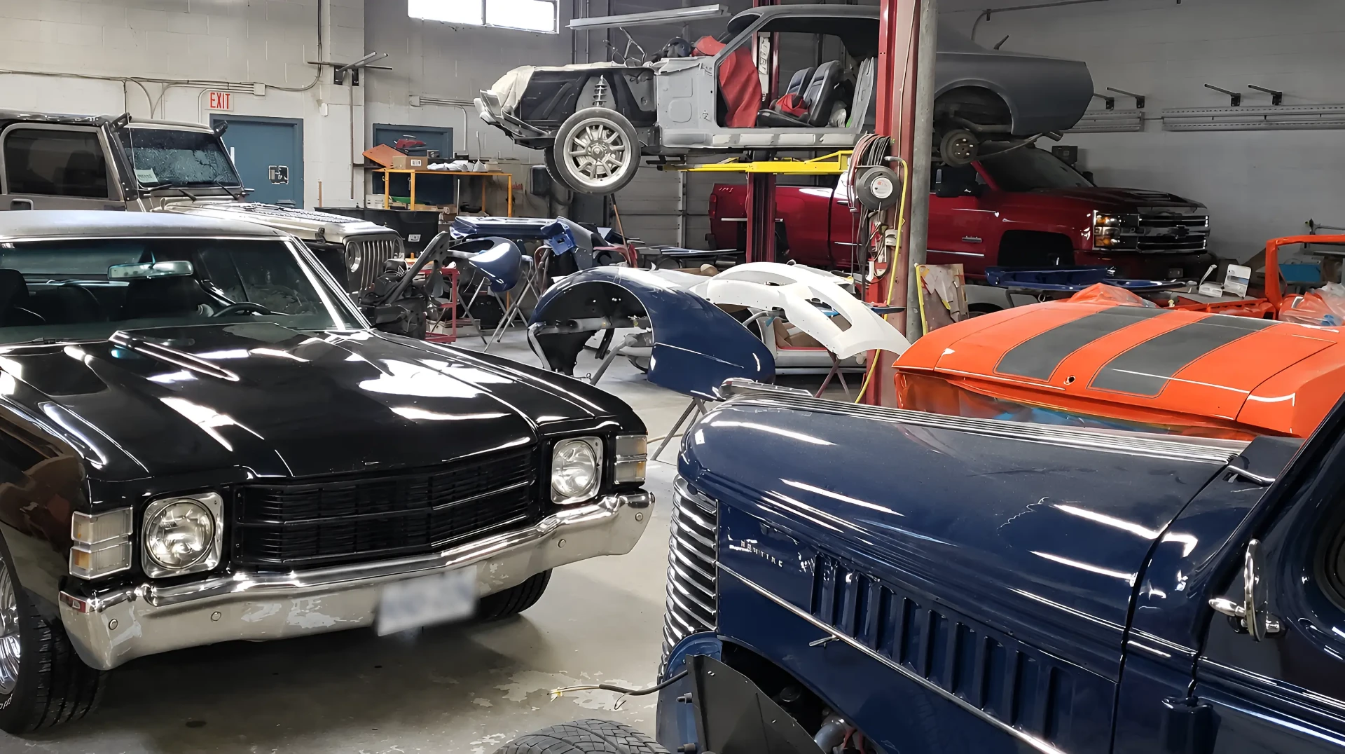 Black Cherry Autoworks workshop interior with classic vehicles under restoration